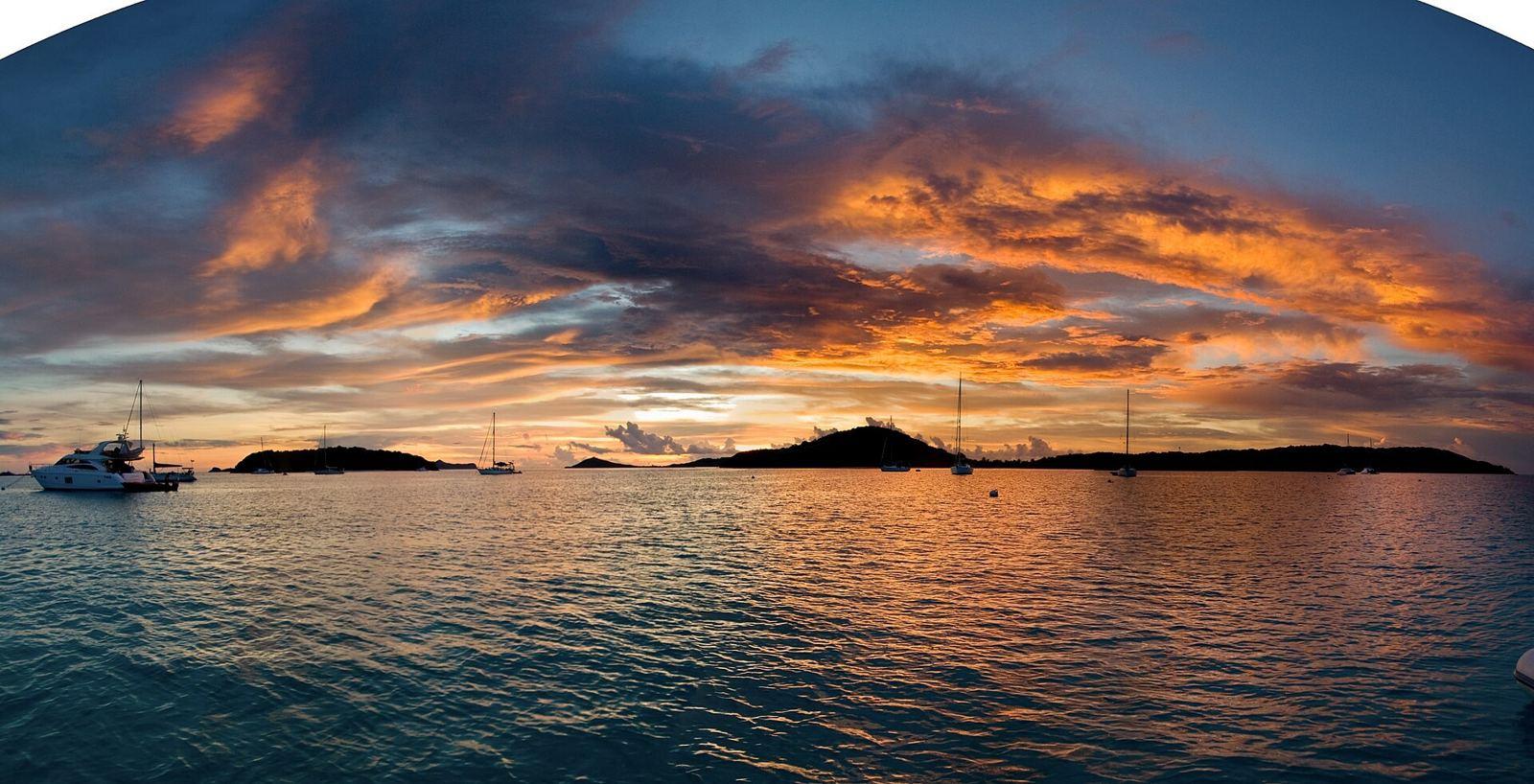 Sunset over the Tobago Cays with anchored sailing boats